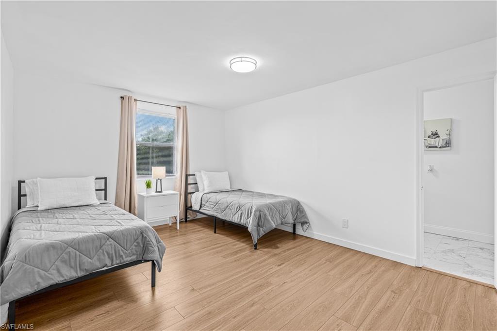 3303 6th Street Southwest Lehigh Acres, FL 33976 - Photo 17 of 23 a spacious bedroom with a bed and wooden floor