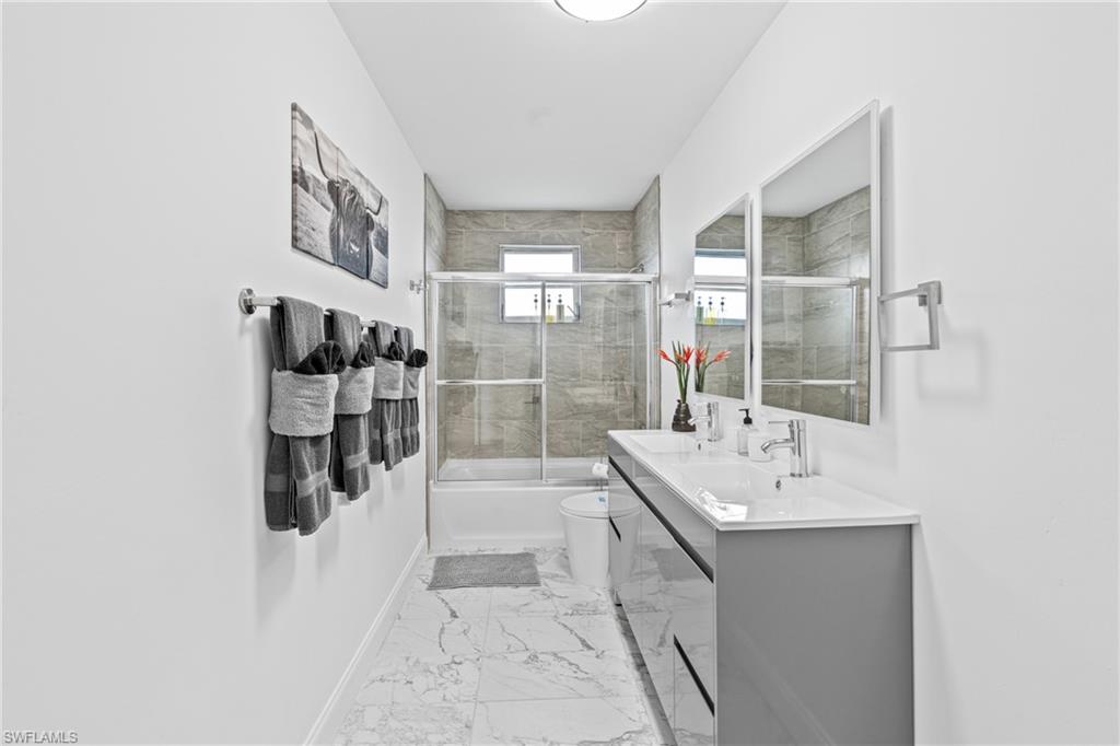 3303 6th Street Southwest Lehigh Acres, FL 33976 - Photo 19 of 23 a bathroom with a tub sink and mirror