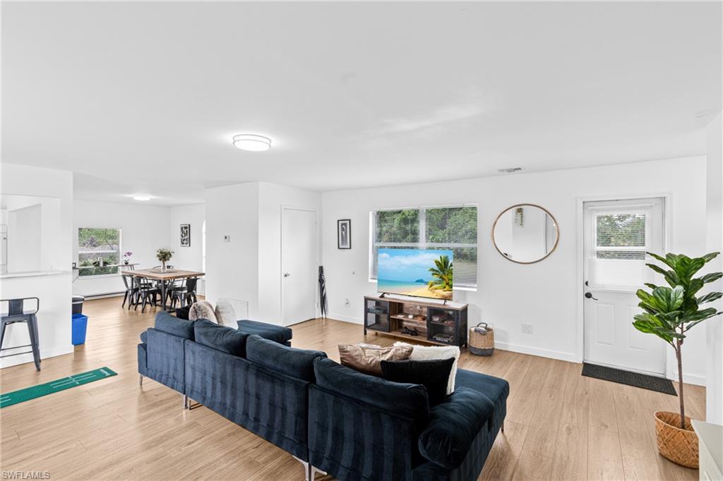 3303 6th Street Southwest Lehigh Acres, FL 33976 - Photo 6 of 23 a living room with furniture kitchen view and a wooden floor