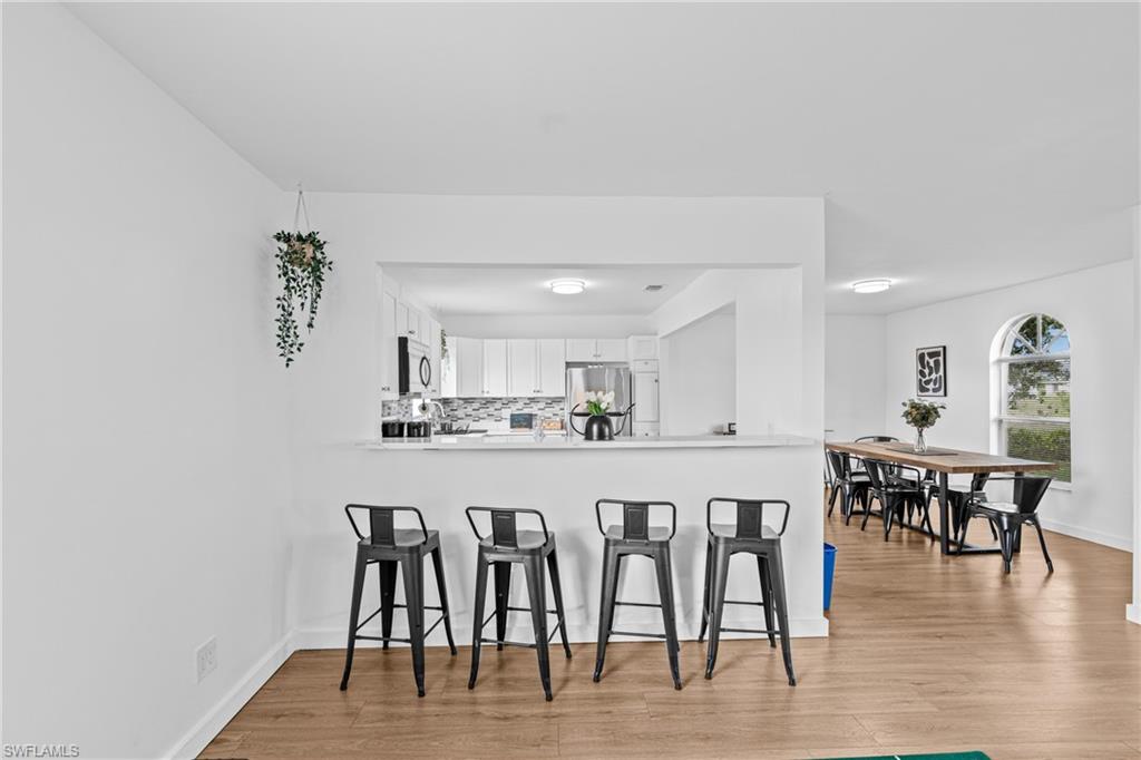 3303 6th Street Southwest Lehigh Acres, FL 33976 - Photo 7 of 23 a large white kitchen with a table and chairs