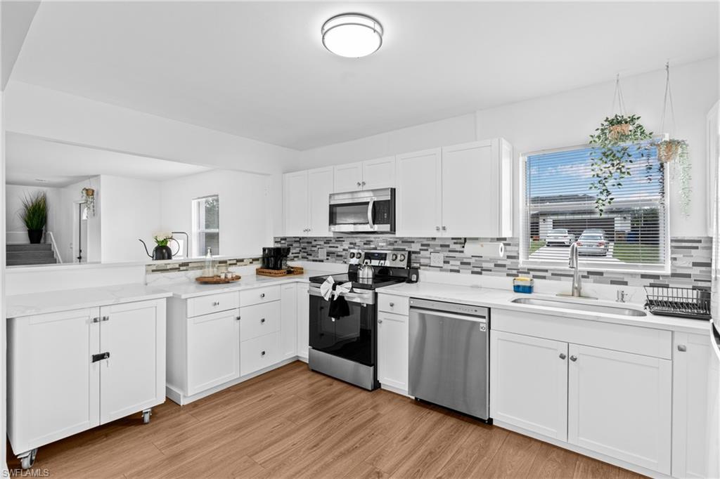 3303 6th Street Southwest Lehigh Acres, FL 33976 - Photo 8 of 23 a kitchen with a sink cabinets and wooden floor