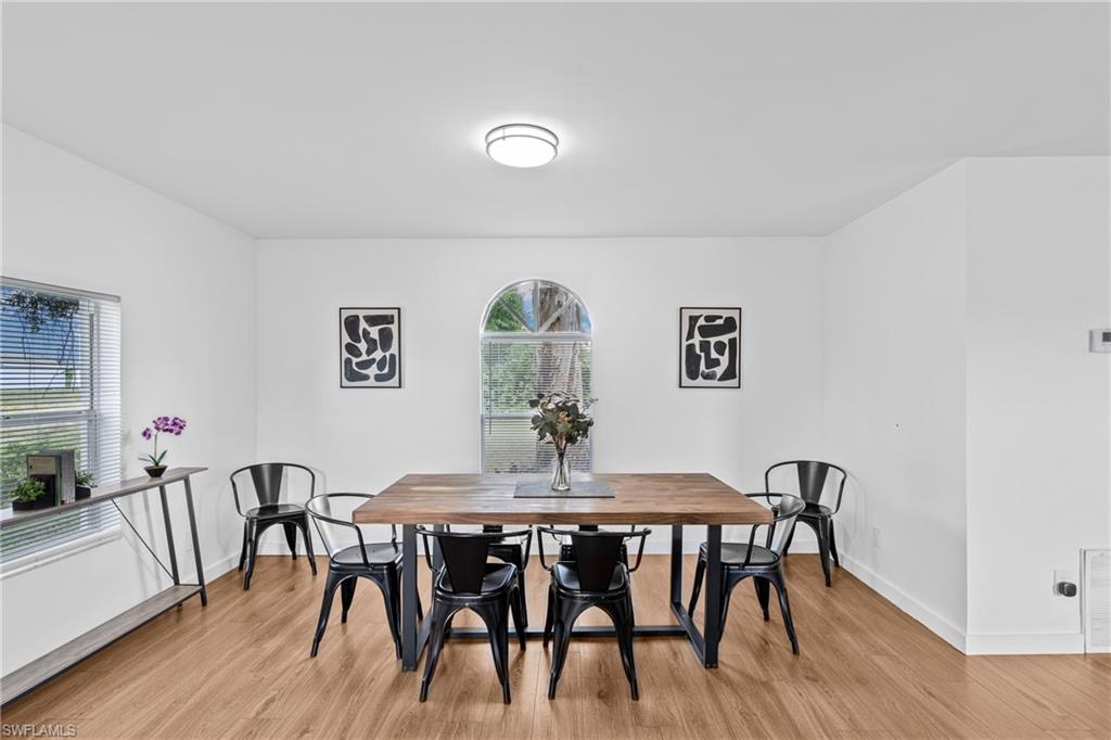 3303 6th Street Southwest Lehigh Acres, FL 33976 - Photo 9 of 23 a view of a dining room with furniture and wooden floor