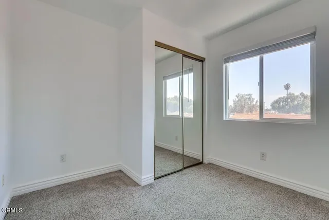 an empty room with windows and closet