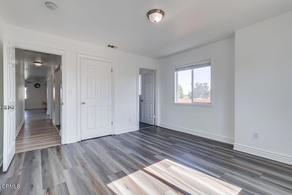 140 East 101st Street Los Angeles, CA 90003 - Photo 17 of 22 an empty room with wooden floor and windows
