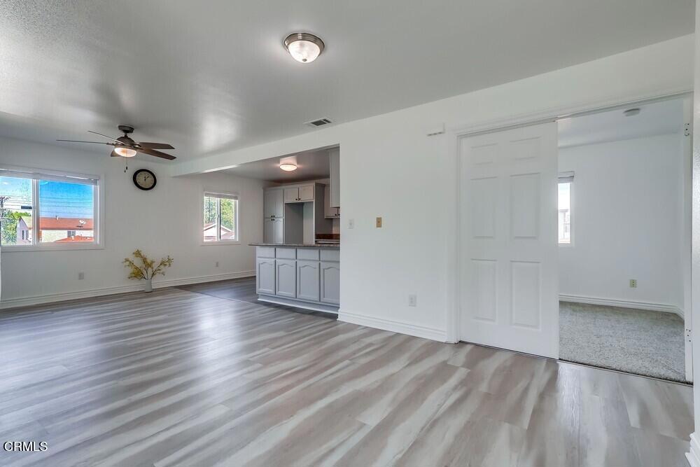 140 East 101st Street Los Angeles, CA 90003 - Photo 5 of 22 an empty room with wooden floor and windows