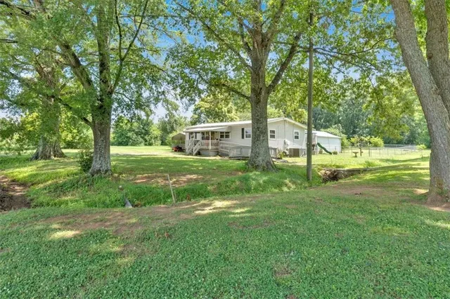 a view of a house with a big yard and sitting area