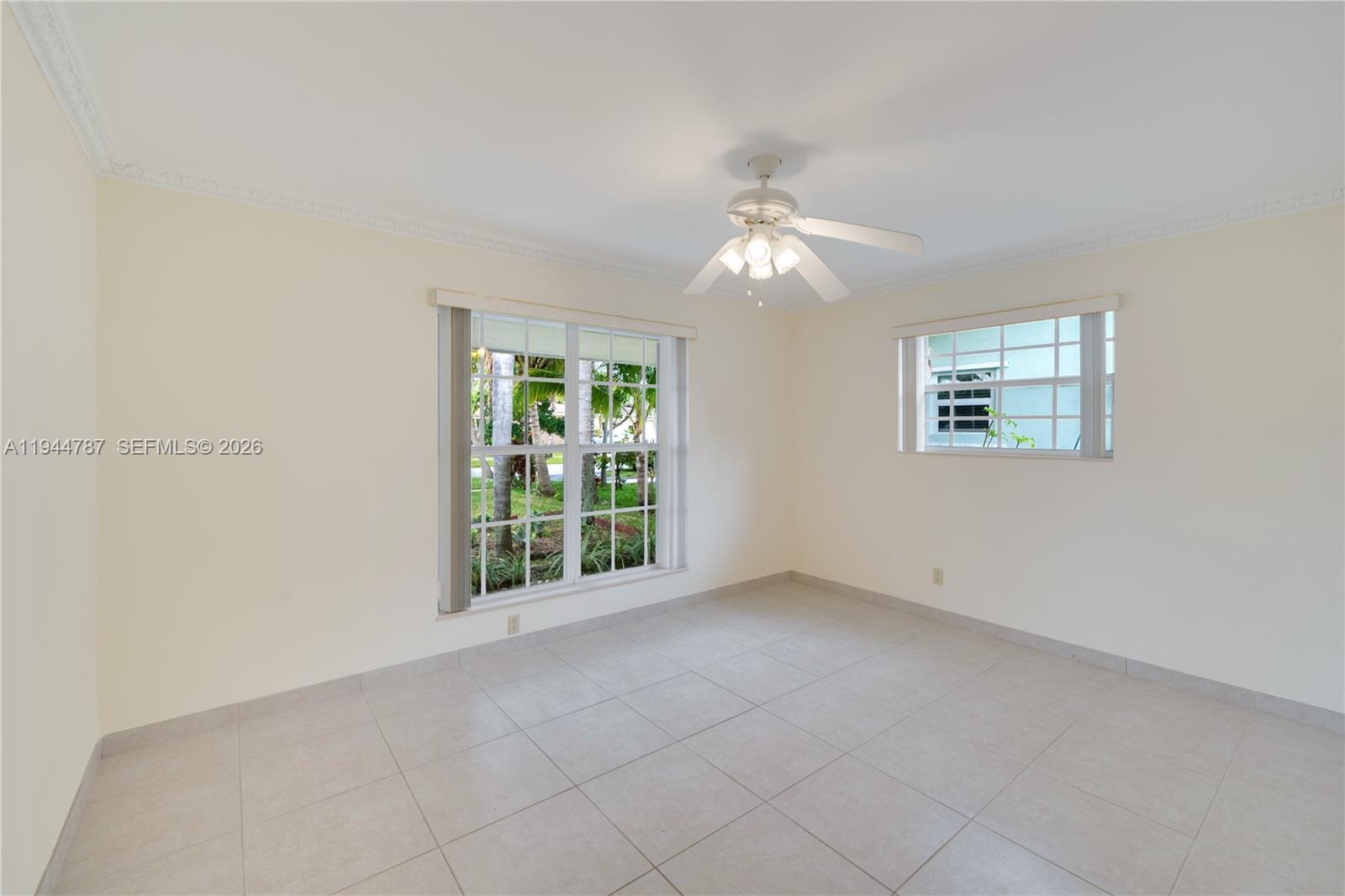5524 Cleveland Street Hollywood, FL 33021 - Photo 20 of 36 an empty room with windows and chandelier fan