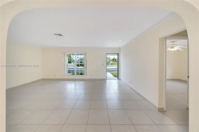 a view of a livingroom with a chandelier fan and windows