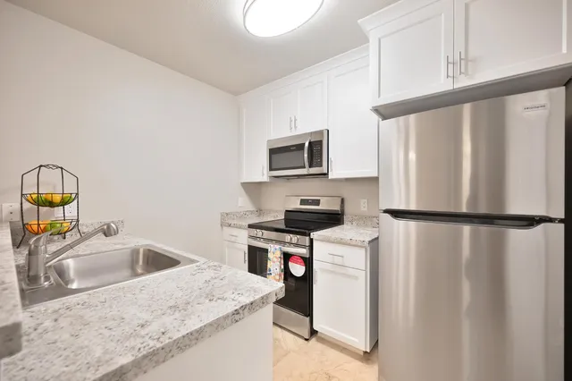 a kitchen with stainless steel appliances granite countertop a sink and a stove
