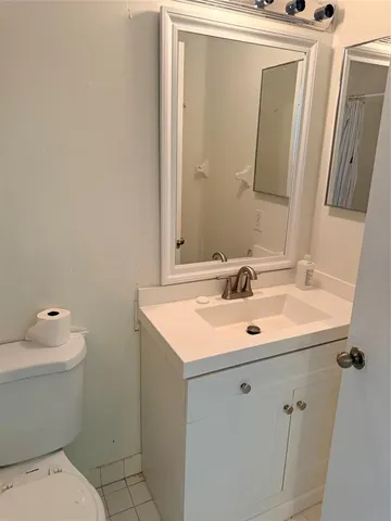 a bathroom with a sink toilet and mirror