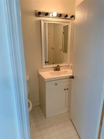 a utility room with a sink a vanity and a mirror