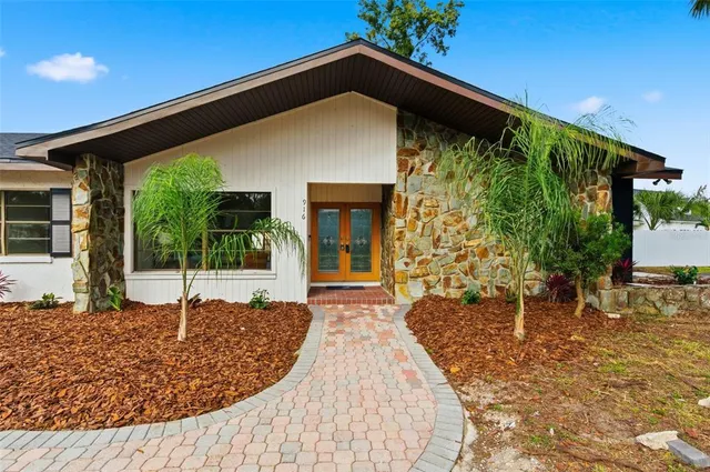 a view of a hallway to a livingroom with furniture wooden floor and windows