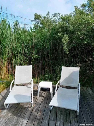 a view of a patio with table and chairs with wooden floor and fence