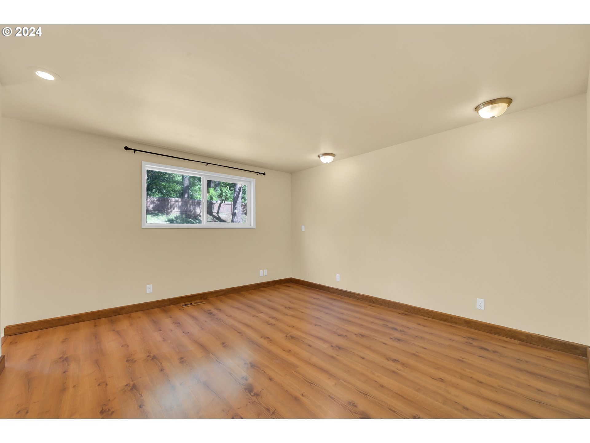 1037 South 70th Street Springfield, OR 97478 - Photo 13 of 44 an empty room with wooden floor and windows