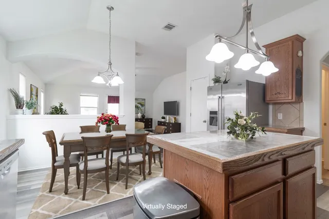 a view of a dining room and a kitchen with a table chairs