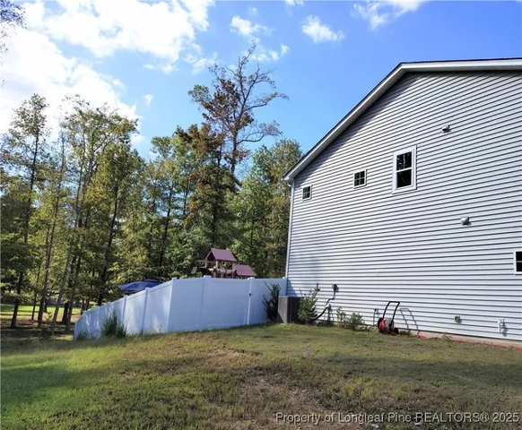 a view of a backyard with plants and large tree