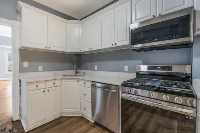 a kitchen with stainless steel appliances granite countertop a stove a sink and a microwave