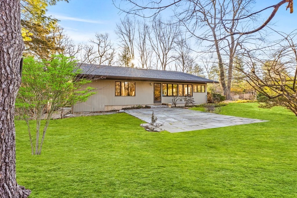 a view of an house with backyard space and tree
