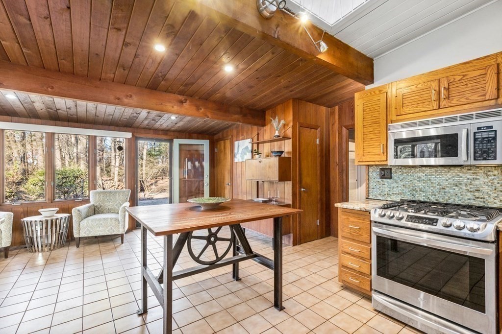 175 Bay Road Sharon, MA 02067 - Photo 11 of 19 a kitchen with stainless steel appliances granite countertop a stove a refrigerator a dining table and chairs with wooden floor
