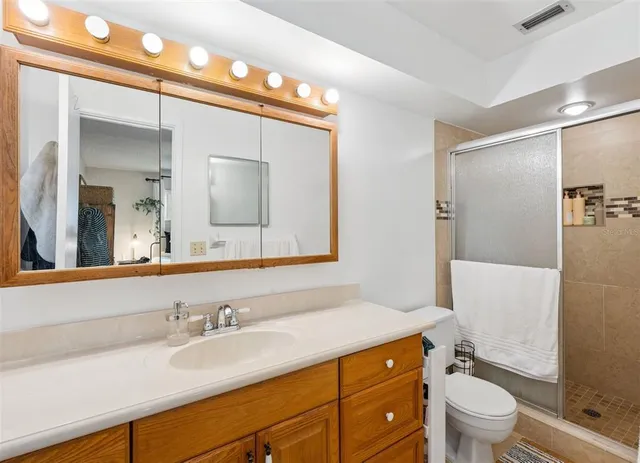 a bathroom with a granite countertop sink a toilet and a mirror