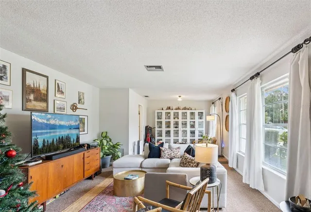 a living room with furniture a flat screen tv and a floor to ceiling window