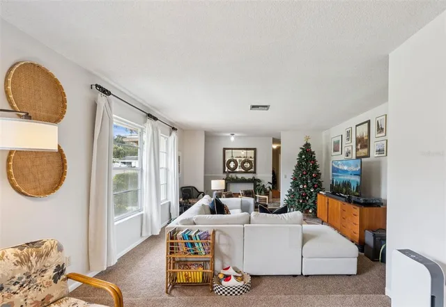a living room with furniture a mirror and a large window