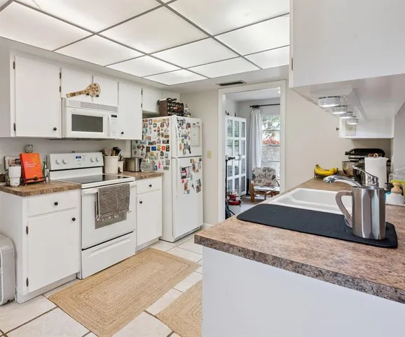 a kitchen that has a lot of cabinets in it and appliances