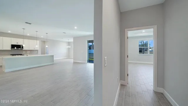 a view of a hallway to kitchen with wooden floor