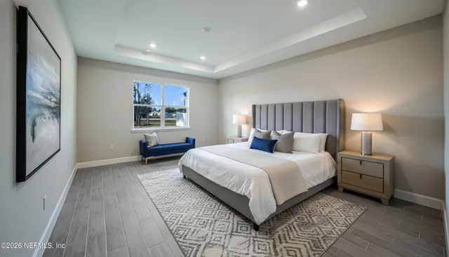 a spacious bedroom with a bed and a night stand