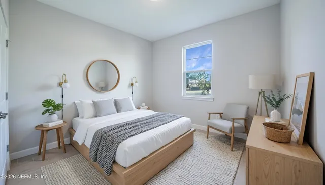 a bedroom with a bed a couch and potted plant