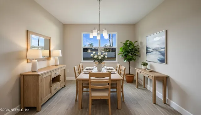 a dining room with furniture a chandelier and wooden floor