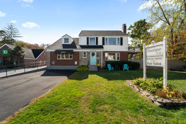 a front view of a house with a yard and potted plants