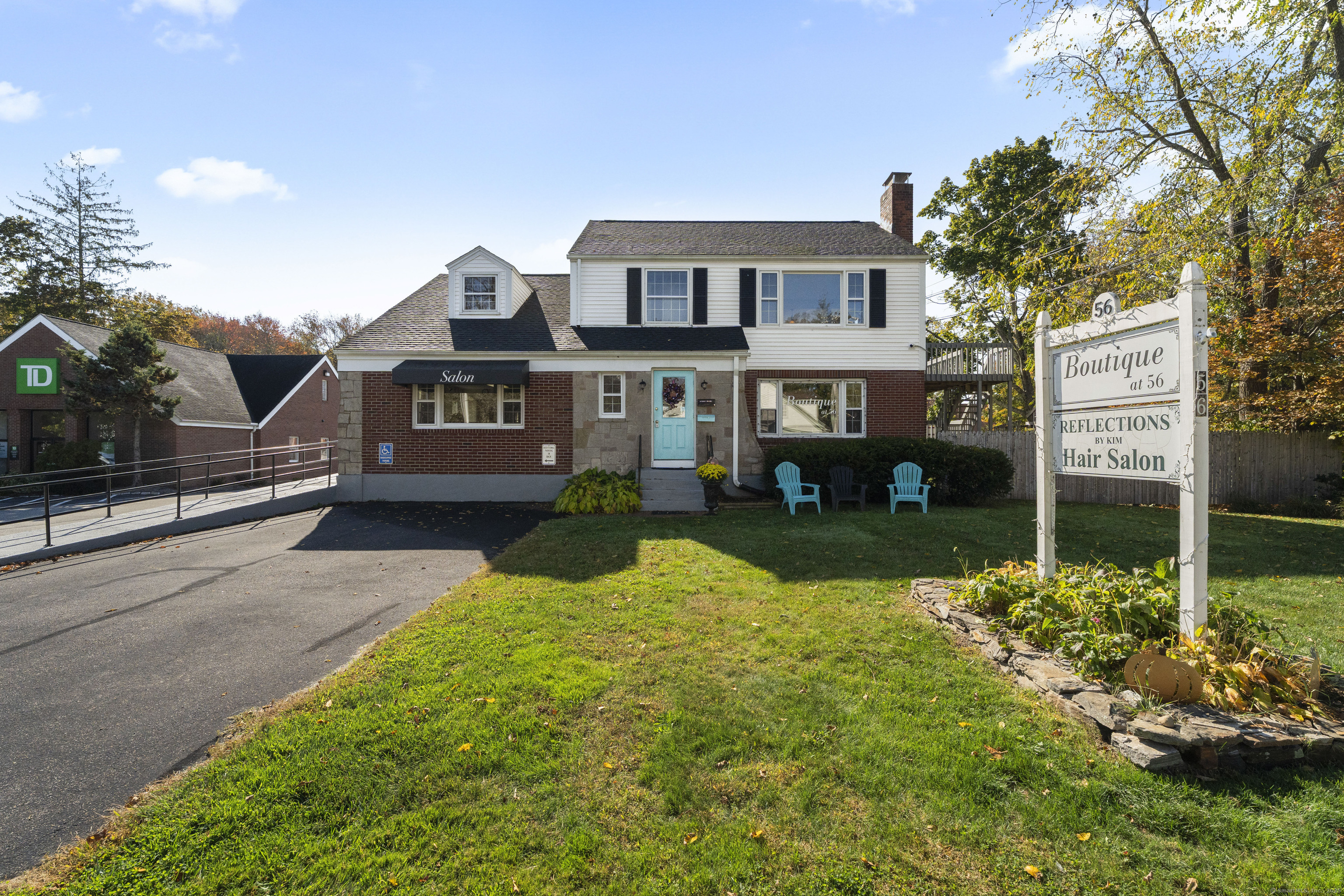 a front view of a house with a yard and potted plants