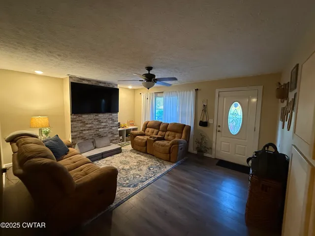 a living room with furniture a ceiling fan and a wooden floor