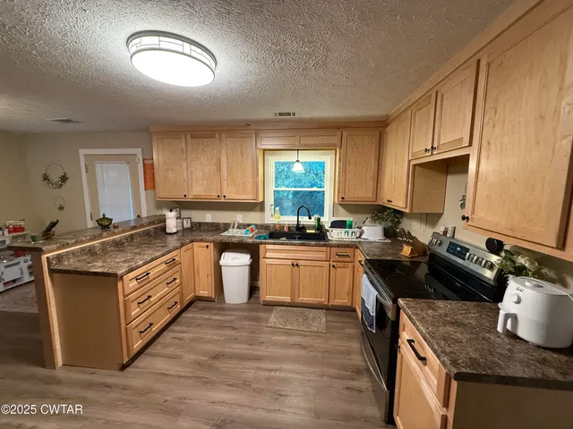a kitchen with stainless steel appliances granite countertop a stove a sink dishwasher and a refrigerator