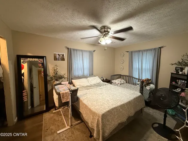 a spacious bedroom with a bed a table and chair