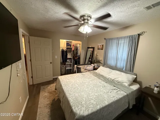 a bed room with a bed mirror and a window