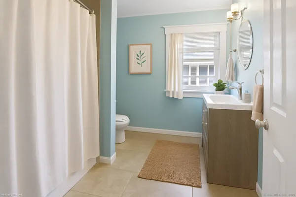 a bathroom with a sink a toilet and a window