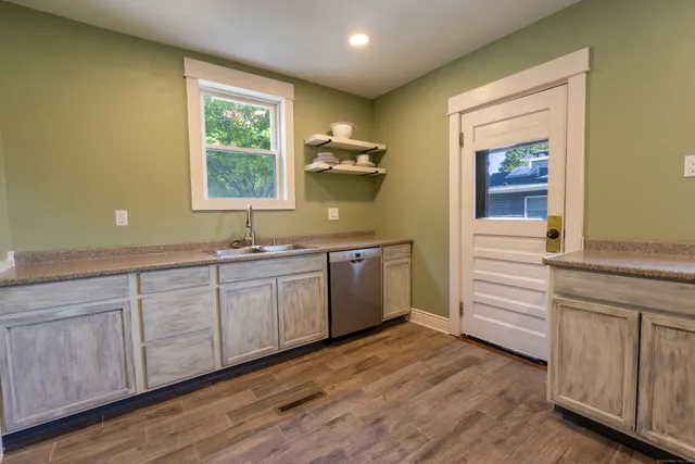 a kitchen with a sink cabinets and wooden floor