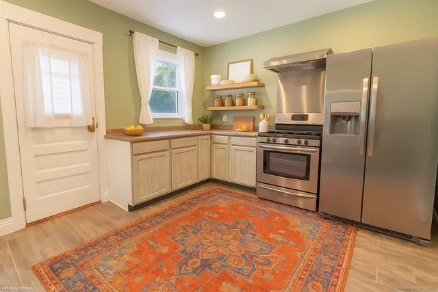 a kitchen with stainless steel appliances granite countertop a stove a sink and a refrigerator