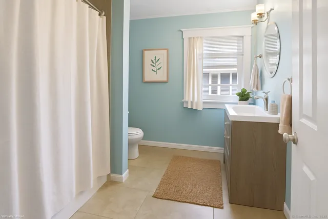 a bathroom with a sink a toilet and a window