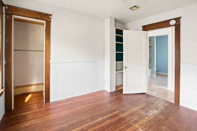 a view of empty room with wooden floor
