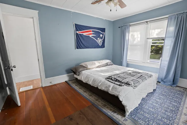 a bedroom with a bed and a painting on the wall
