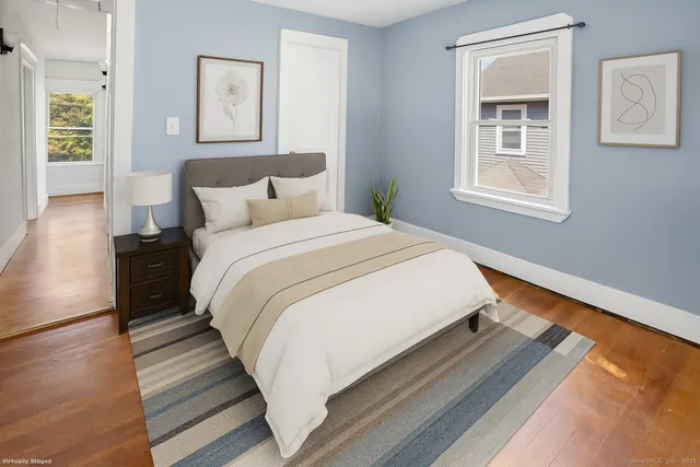 a large bed sitting in a bedroom next to a window