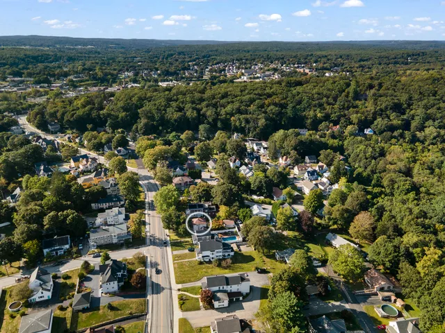 an aerial view of residential houses with outdoor space and trees