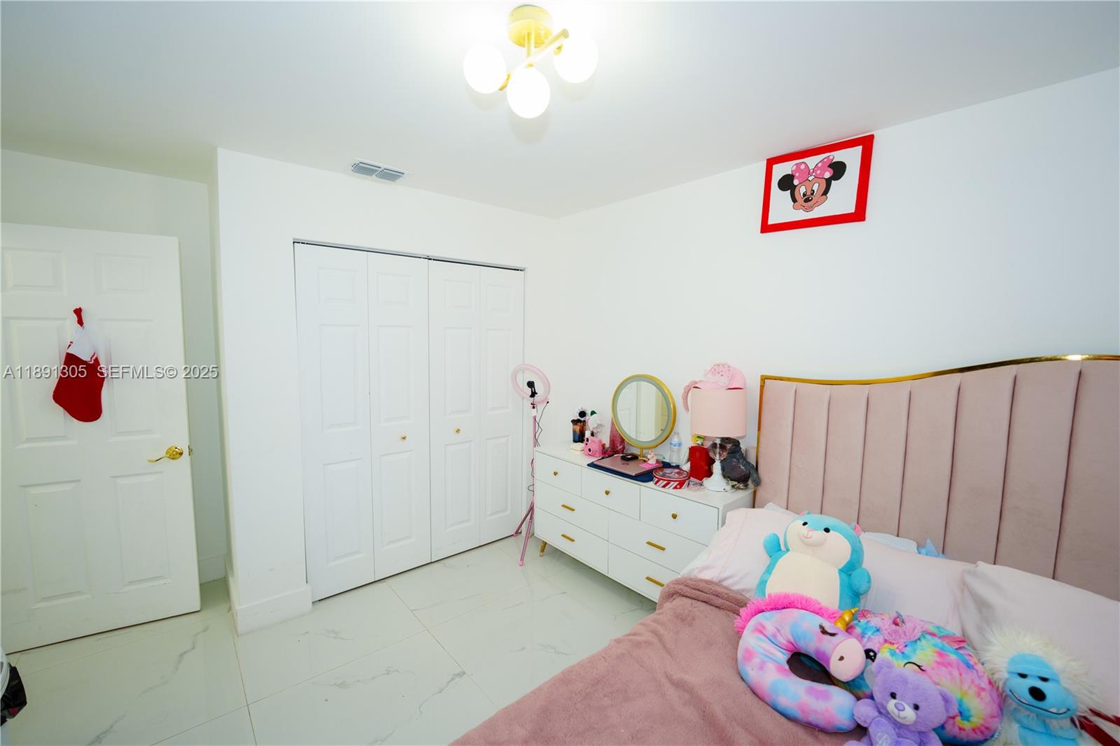 22226 Southwest 98th Place Cutler Bay, FL 33190 - Photo 28 of 29 a bedroom with a bed and a chandelier