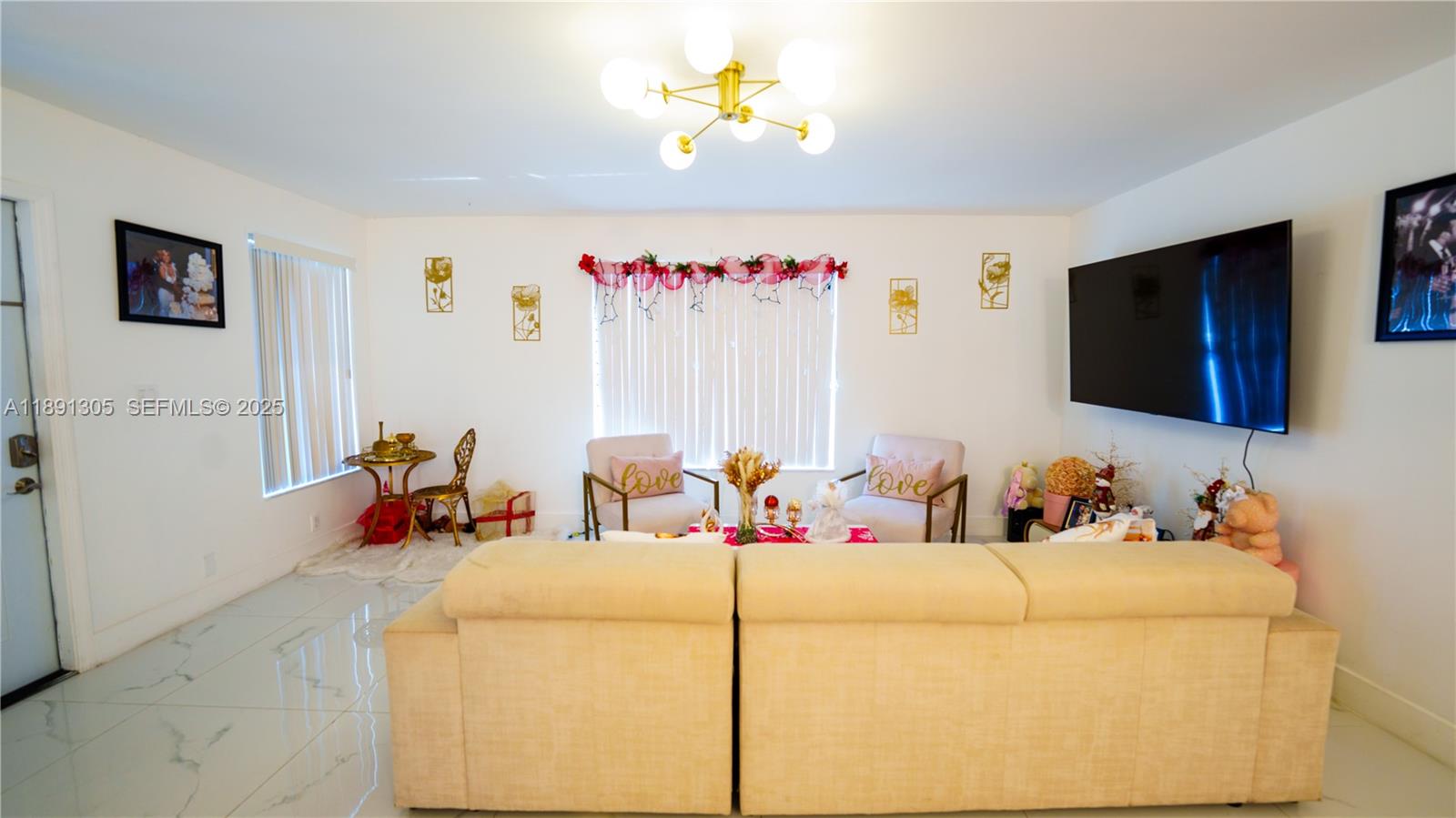 22226 Southwest 98th Place Cutler Bay, FL 33190 - Photo 10 of 29 a living room with furniture and a flat screen tv