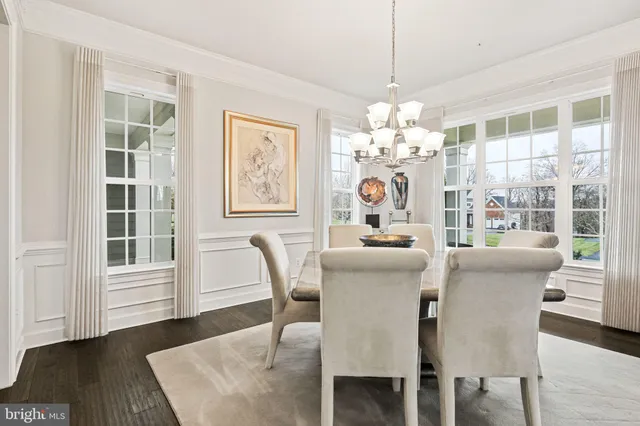 a dining room with furniture a chandelier and wooden floor