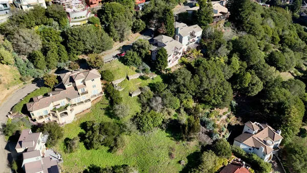 a view of a white house with a yard and sitting area