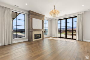1141 East Lost Ridge Drive Washington, UT 84780 - Photo 58 of 108 Spacious room featuring light wood-finish flooring and a central fireplace with an ornate wood mantle and light stone surround